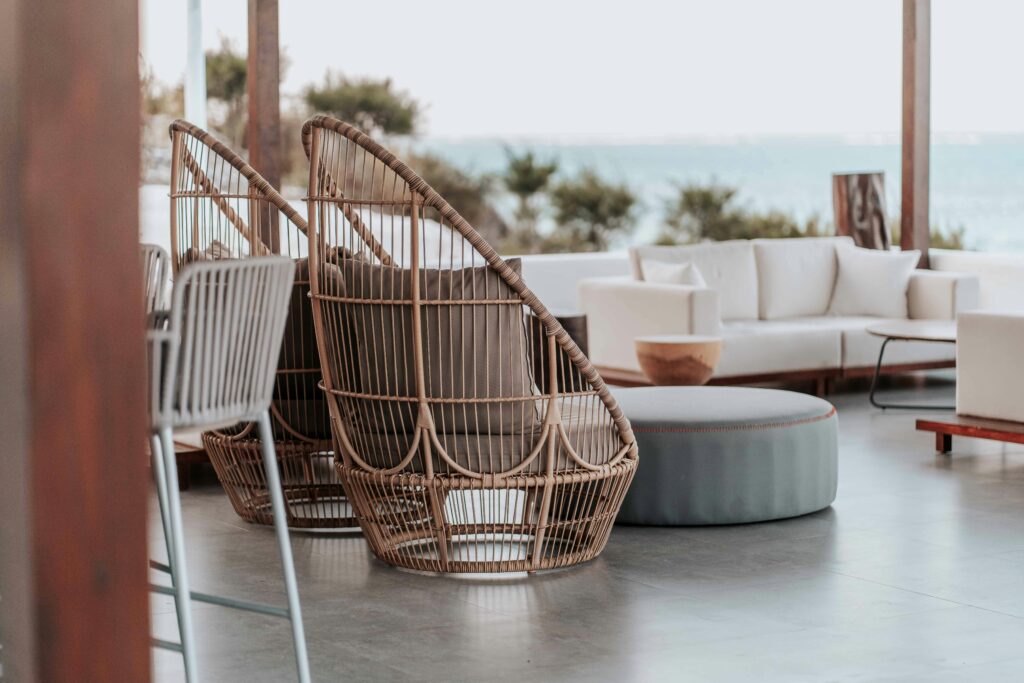 Stylish outdoor terrace featuring wicker chairs and sofas by the sea.
